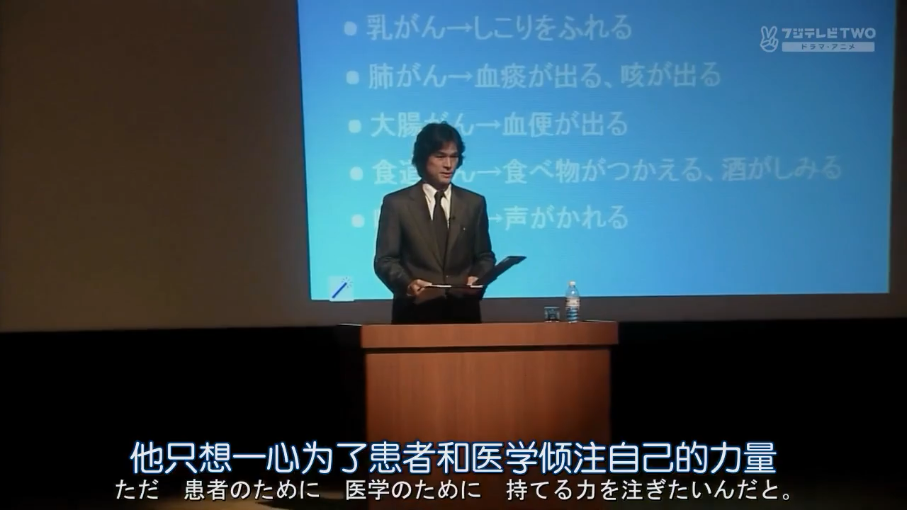 里见在市民公开讲座上演讲，画面字幕为财前的评论